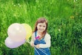 Portrait of cute little girl with beautiful smile holding toy balloons in hand on the flower meadow, happy childhood Royalty Free Stock Photo