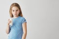 Portrait of cute little girl with blond long hair and blue eyes looking in camera with milk mustache and funny face Royalty Free Stock Photo