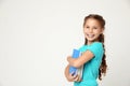 Portrait of cute little girl with books on background, space for text. Reading concept