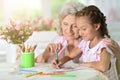 Portrait of a little girl drawing with her grandmother Royalty Free Stock Photo