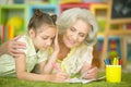 Cute little girl drawing with her grandmother Royalty Free Stock Photo