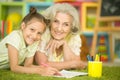 Portrait of a cute little girl drawing with her grandmother Royalty Free Stock Photo