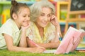 Portrait of a cute little girl drawing with her grandmother Royalty Free Stock Photo