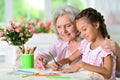 Portrait of a cute little girl drawing with her grandmother Royalty Free Stock Photo