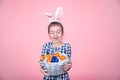 Portrait of a cute little girl with an Easter egg basket on an isolated pink background Royalty Free Stock Photo