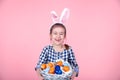 Portrait of a cute little girl with an Easter egg basket on an isolated pink background Royalty Free Stock Photo