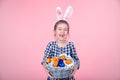 Portrait of a cute little girl with an Easter egg basket on an isolated pink background Royalty Free Stock Photo