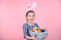 Portrait of a cute little girl with an Easter egg basket on an isolated pink background Royalty Free Stock Photo