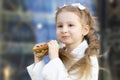 Portrait of cute little girl eating sandwich during break between classes. healthy unhealthy food for kid Royalty Free Stock Photo