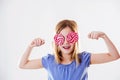 Portrait of a cute little girl having fun with two lollipops, covering her yes with them. Royalty Free Stock Photo