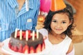 Strawberries for the birthday girl. Portrait of a cute little girl and her brother posing with a birthday cake at home. Royalty Free Stock Photo