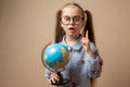 Little girl in glasses holding globe Royalty Free Stock Photo