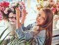 Portrait of a cute little girl with long brown hair and piercing glance wearing a stylish dress, posing with flowers Royalty Free Stock Photo