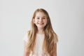 Portrait of cute little girl with long light hair smiling brightfully, looking upside on colorful flying balloons with Royalty Free Stock Photo