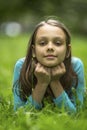portrait of cute little girl lying on green grass. Royalty Free Stock Photo