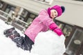 Portrait of cute little girl making smowman. at bright winter day. Adorable child playing with snow outdoors. Funny Royalty Free Stock Photo