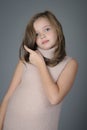 Portrait of a cute little girl pushes her hair from her face.