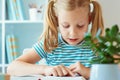 Portrait of a cute little girl read book at the table in classroom Royalty Free Stock Photo