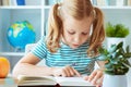 Portrait of a cute little girl read book at the table in classroom Royalty Free Stock Photo