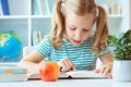 Portrait of a cute little girl read book at the table in classroom Royalty Free Stock Photo