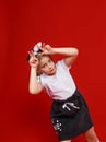 Portrait of a cute little girl in a white T-shirt and black skirt on a red background. Royalty Free Stock Photo