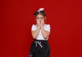 Portrait of a cute little girl in a white T-shirt and black skirt on a red background. Royalty Free Stock Photo