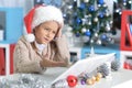 Little girl in Santa hat with laptop Royalty Free Stock Photo