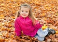 Portrait of cute little girl sitting in leaves Royalty Free Stock Photo