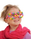 Portrait of cute little girl wearing funny glasses, decorated with colorful sweets, smarties Royalty Free Stock Photo