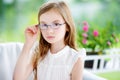 Portrait of cute little girl wearing glasses at home. Vision, health, ophthalmology concept.