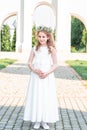 Portrait of cute little girl on white dress and wreath on first holy communion background church gate. first communion girl Royalty Free Stock Photo