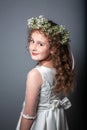 Portrait of cute little girl on white dress and wreath of first holy communion. First Communion Day. Studio photo Royalty Free Stock Photo