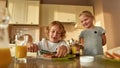 Portrait of cute little kids preparing lunch or breakfast for themselves. Cheerful boy spreading chocolate nut butter on Royalty Free Stock Photo