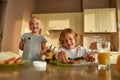 Portrait of cute little kids preparing lunch or breakfast for themselves. Cheerful boy spreading chocolate nut butter on Royalty Free Stock Photo