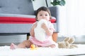 Portrait of cute little 7 months old multiracial, asian and caucasian, newborn baby girl sitting on floor having teeth growing Royalty Free Stock Photo