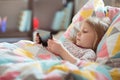 Portrait of cute little preschool child girl laying ill with tablet at homeschooling Royalty Free Stock Photo