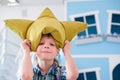 Portrait of a cute little school boy with yellow pillow crown