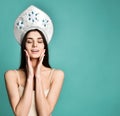 Portrait of cute lovely girl in kokoshnik hat sending blowing kiss with pout lips looking at camera isolated on green background. Royalty Free Stock Photo