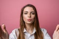 Portrait of cute lovely girl sending blowing kiss with pout lips looking at camera isolated on pink background Royalty Free Stock Photo