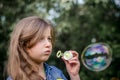 Portrait of cute lovely little girl blowing soap bubbles. Royalty Free Stock Photo