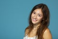 Portrait of cute morning girl. Beautiful cheerful teen girl looking at camera over blue background. Young woman posing in pajamas