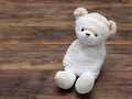 Portrait of cute mummy teddy bear doll bind with white gauze or bandage on dark wooden background Royalty Free Stock Photo