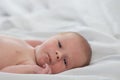 Portrait of a cute newborn baby looking into the camera. Little boy 7 days, one week. The baby lies on a white silk blanket. Royalty Free Stock Photo