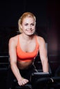 Portrait of a cute nice female workout on fitness the exercise bike dark at gym. Royalty Free Stock Photo