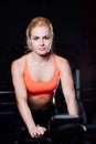 Portrait of a cute nice female workout on fitness the exercise bike dark at gym. Royalty Free Stock Photo