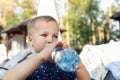 Portrait of cute playful little caucasian blond thirsty toddler boy kid holding plastic bottle and drinking water on hot Royalty Free Stock Photo