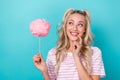 Portrait of cute positive lady finger touch lip look empty space hold cotton candy stick isolated on teal color Royalty Free Stock Photo