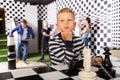 Preteen boy contemplating solving puzzle in chess quest room Royalty Free Stock Photo