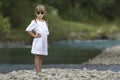 Portrait of cute pretty funny young girl with blond braids in white dress and dark sunglasses. Royalty Free Stock Photo