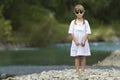 Portrait of cute pretty funny young girl with blond braids in white dress and dark sunglasses Royalty Free Stock Photo